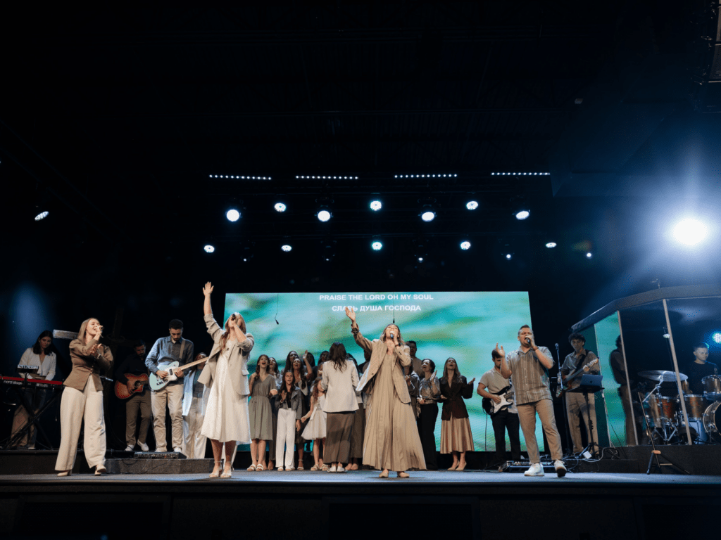 Image of everyone on a stage while singing